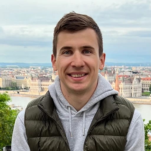 Person smiling with a city view in the background.