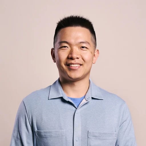 Person smiling in a light blue shirt against a plain background.