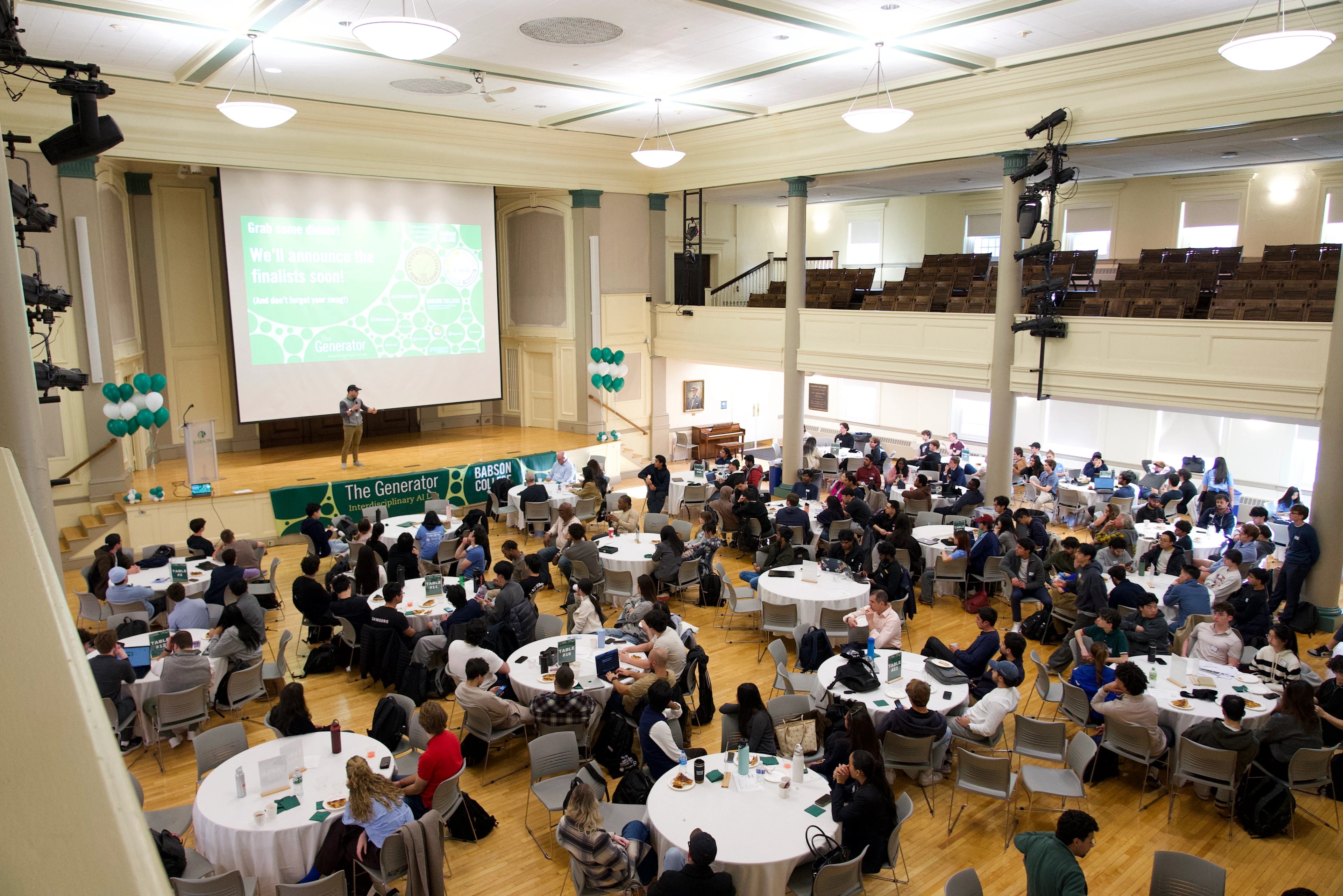 A large audience attends a conference at Babson College, awaiting finalist announcements
